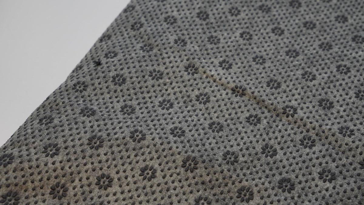 Grey non-slip backing cloth texture close-up